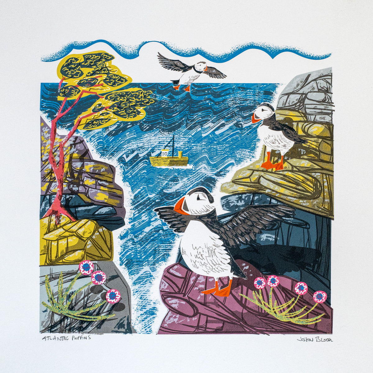 Atlantic Puffins hand pulled screenprint. It features three puffins, one flying and two on cliffs, with the sea between the cliffs and a boat on the sea.