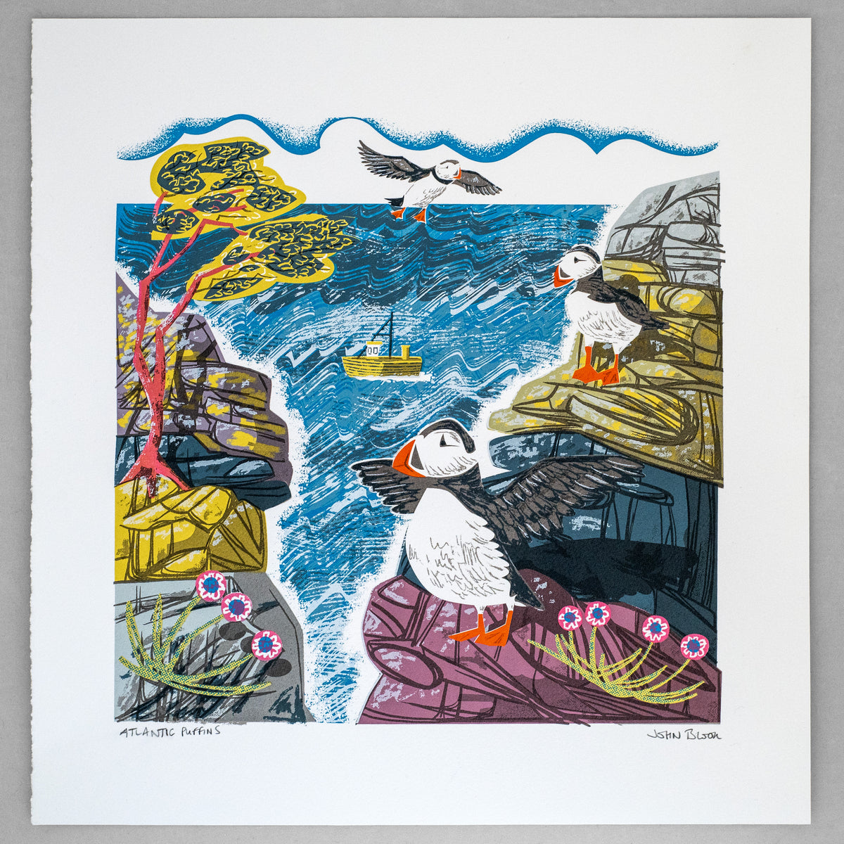 Atlantic Puffins hand pulled screenprint. It features three puffins, one flying and two on cliffs, with the sea between the cliffs and a boat on the sea.