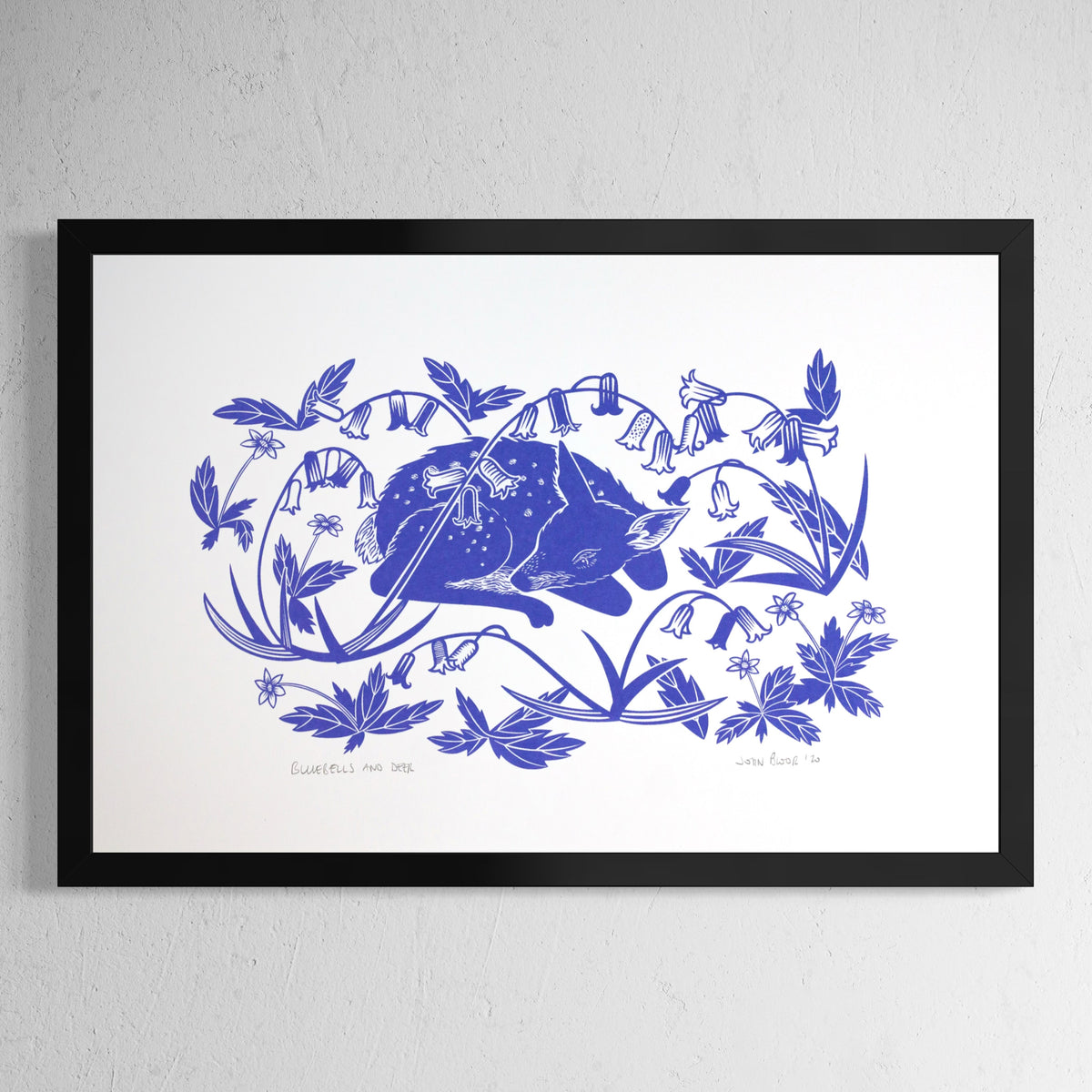 Bluebells and Deer hand pulled screenprint. It depicts a young fawn sleeping amongst bluebells. Shown in a black frame.