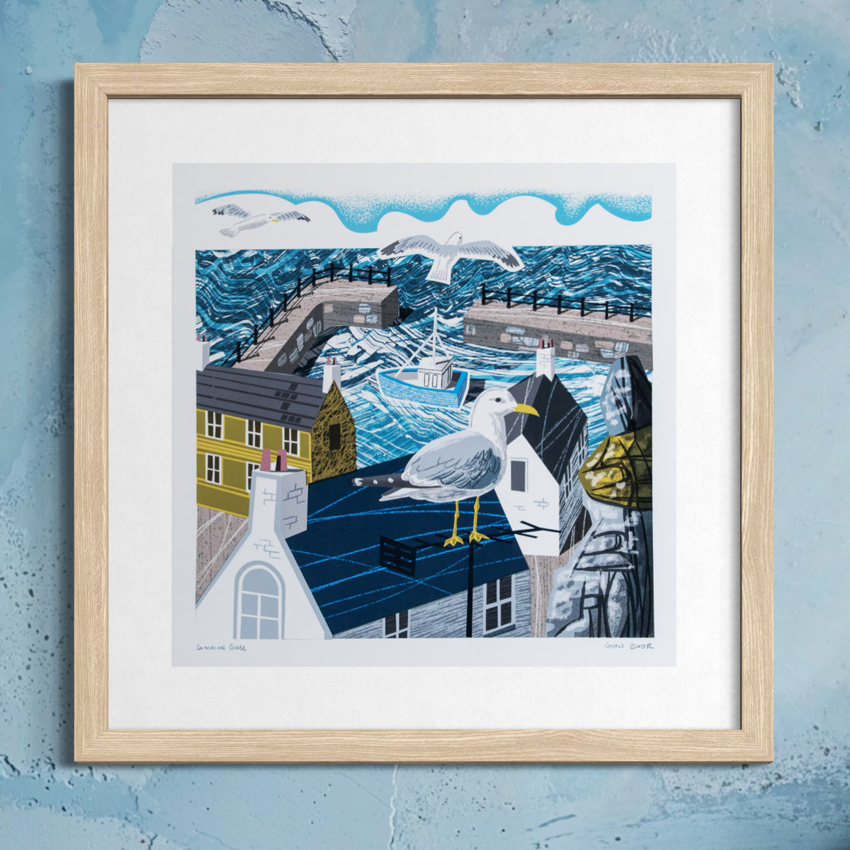 Framed artwork of a seagull on a rooftop with a coastal scene in the background.