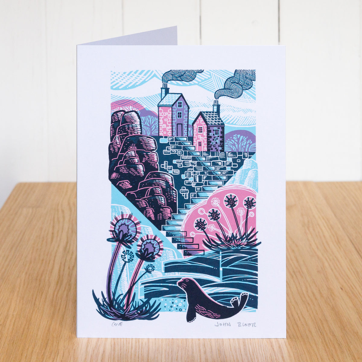 Cove card. It depicts a quiet cove, with steps leading down to it. At the top of the steps are two houses. 