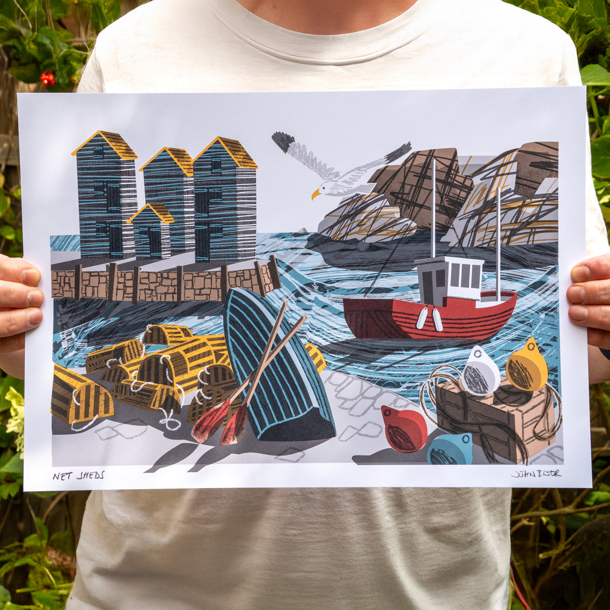 A digital print called Net Sheds. It features a harbour and boat with net sheds on the quay, headland behind, buoys, lobster pots and upturned boat.