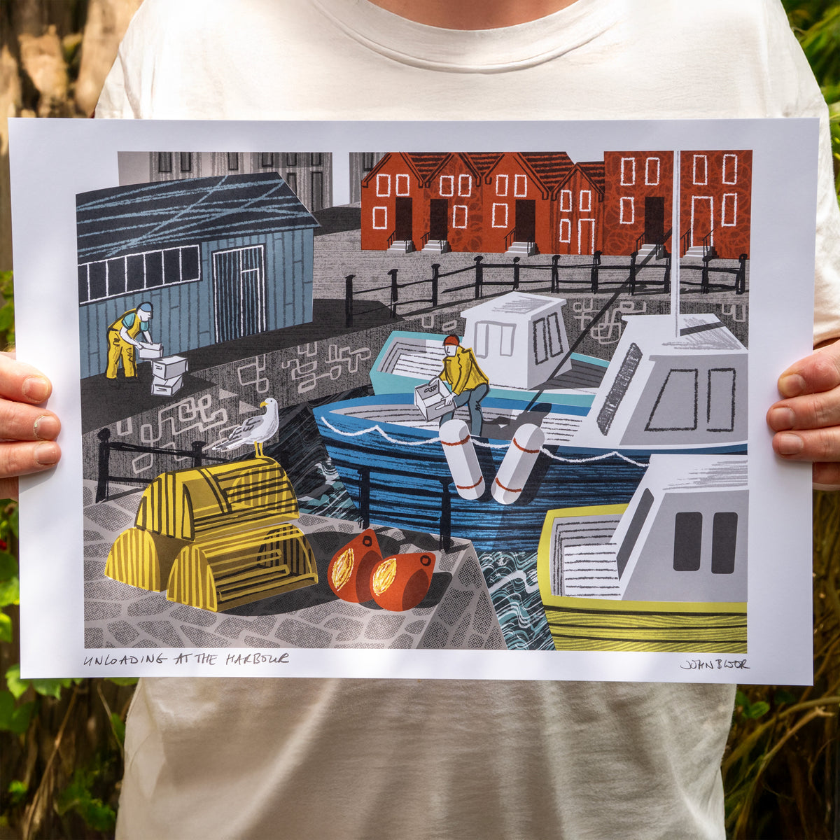 A print titled Unloading at the Harbour, featuring fishermen and women unloading at a harbour, from boats to the harbour wall. It also features a fish market, houses, boats, lobster pots and buoys.