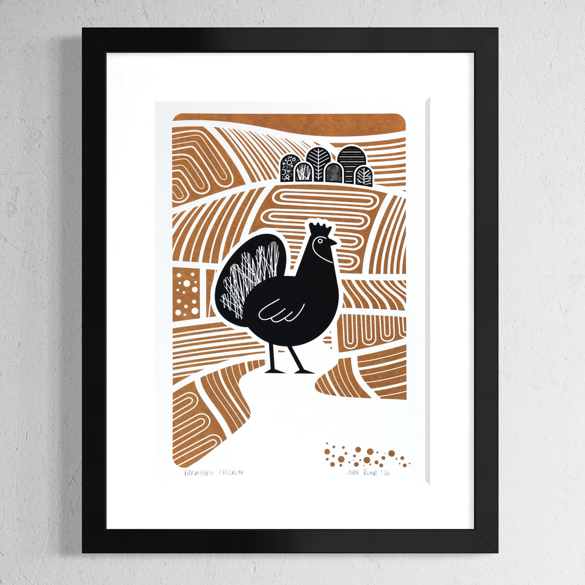 A hand pulled screen print in a geometric design depicting a chicken in black, standing in brown ploughed fields, with black trees behind. Shown in a black frame.