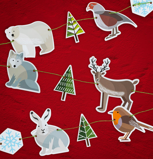 A festive Christmas garland which is made of six Winter animals, two snowflakes and three fir trees. It features polar bear, partridge, Arctic fox, reindeer, Arctic hare and robin.