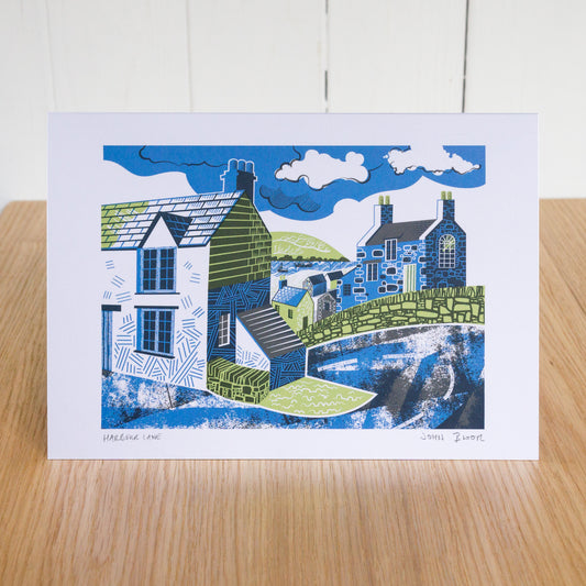Harbour Lane greetings card depicting a road going down a hill into a harbour with houses on either side. 