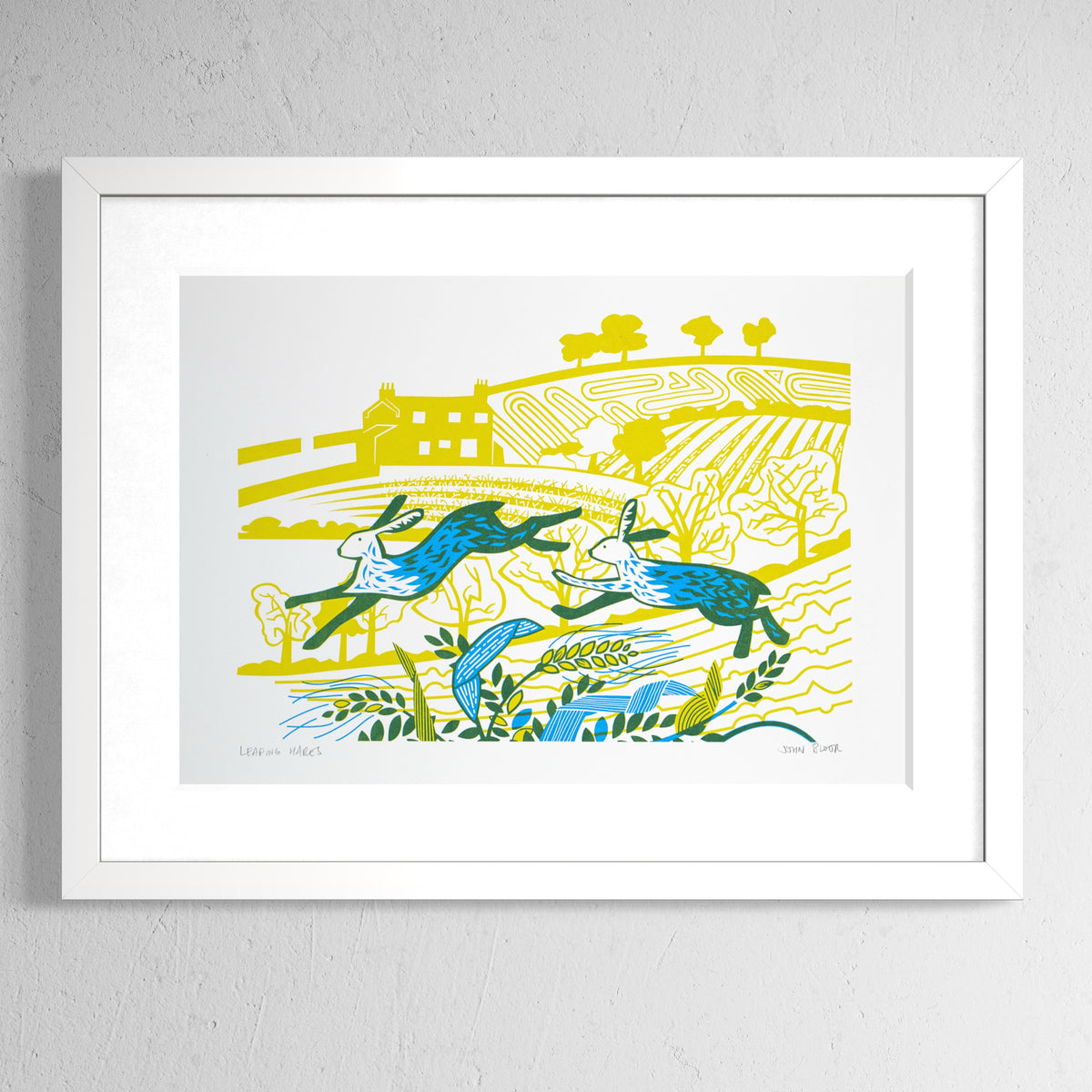 Leaping Hares screenprint in yellow and cyan showing two hares leaping over grasses and wheat in front of a countryside scene. Shown in a white frame.