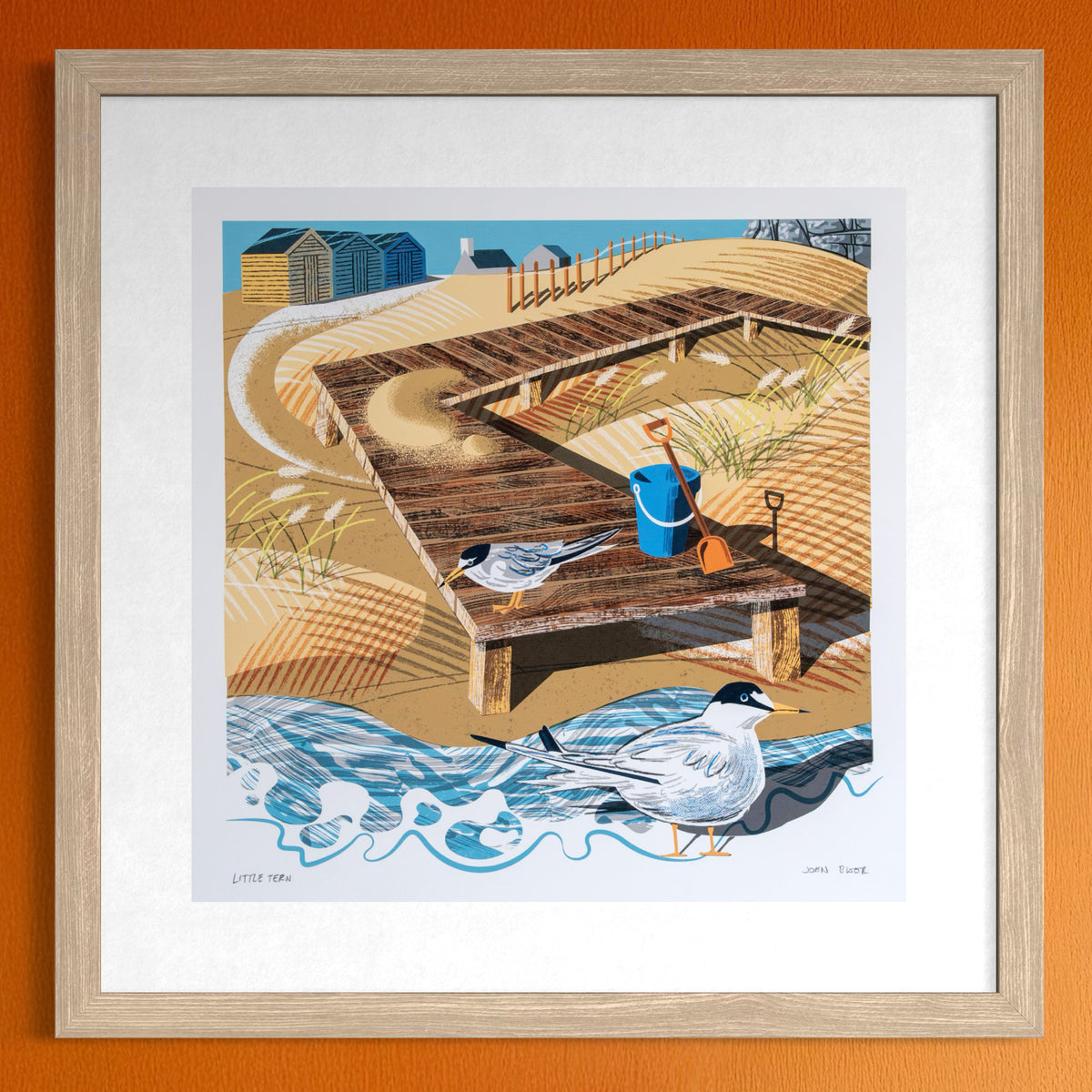 Little Tern, British coastal bird digital print. It shows two Little Terns standing at the end of a wooden walkway which comes across a beach. In the background are beach huts.