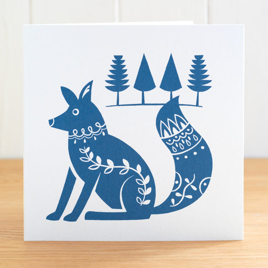 This is a Scandi Forest influenced greetings card featuring a fox with fir trees behind. It is printed in dark blue.