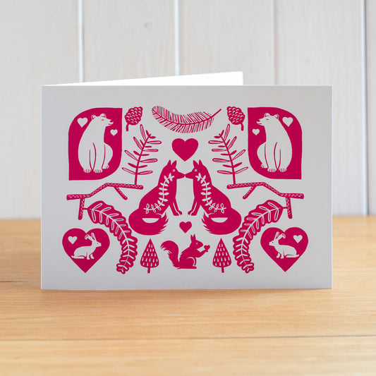 This is a Scandi influenced Valentine's card featuring two foxes, two bears, two hares and a squirrel. The design is in pink.