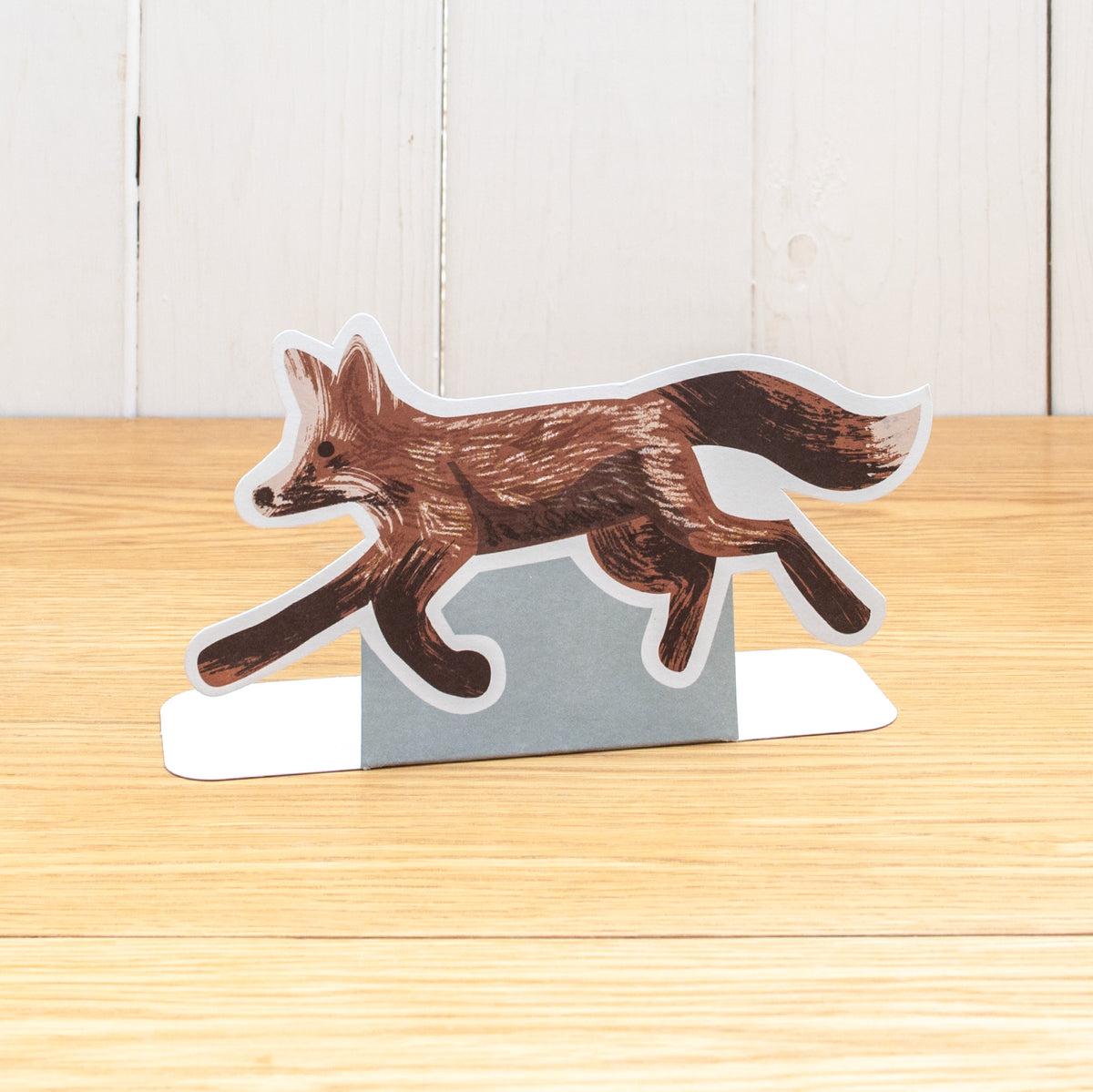 A die cut Fox running, made with natural media marks. It is made of cardboard and stands up.