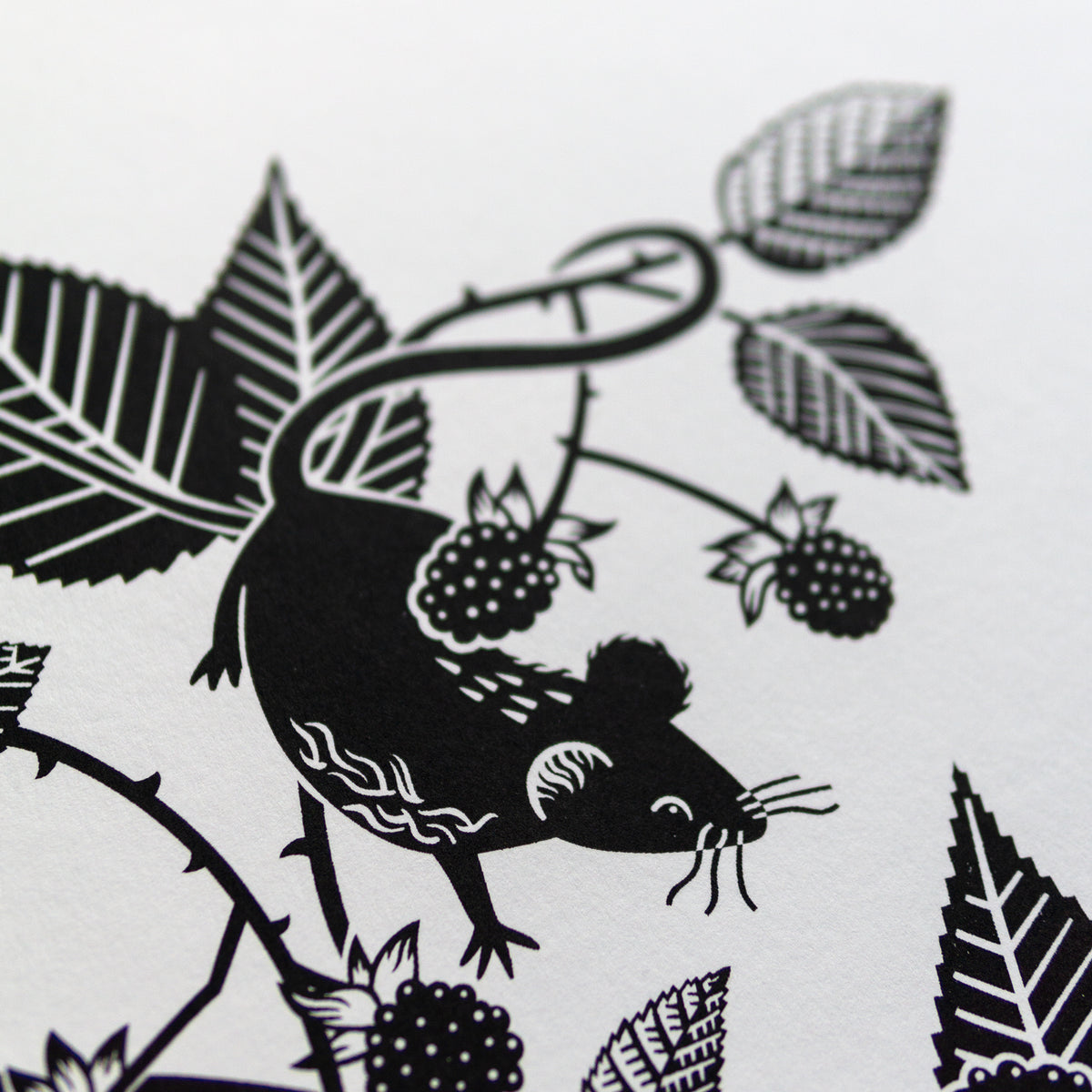 Screenprint detail of a mouse hanging by its tail from brambles.