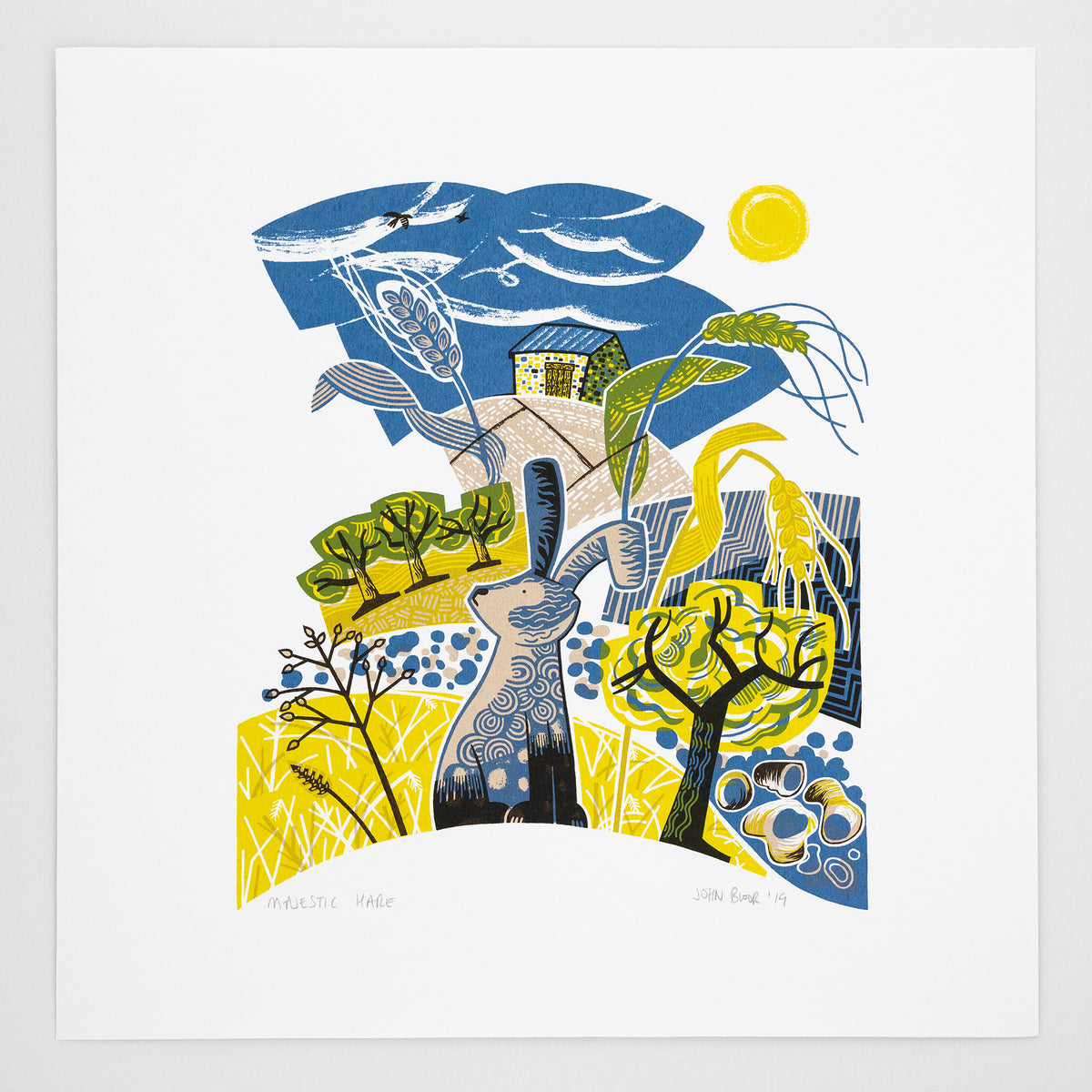Majestic Hare screen print. It depicts a hare sitting in a yellow field with seed heads, trees, pebbles and a barn. 